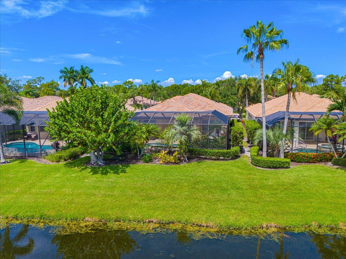 8332 Muirfield Way Port St. Lucie, FL 34986 - Photo 5 of 55 a view of a swimming pool with lawn chairs under an umbrella