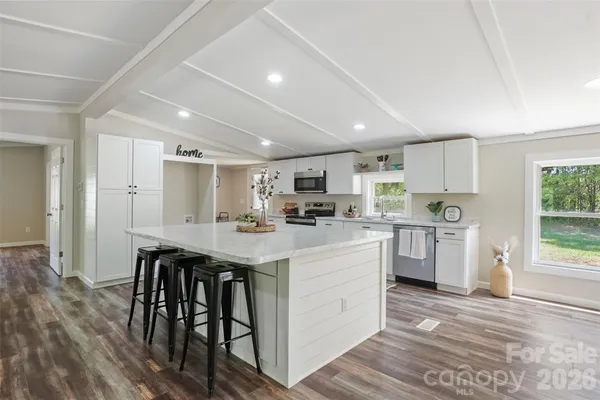 a kitchen with white cabinets and stainless steel appliances
