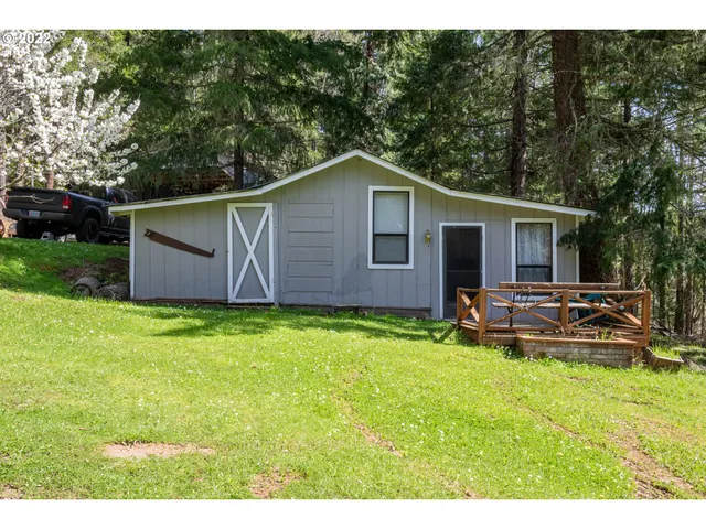 a view of a big house with a big yard and large trees