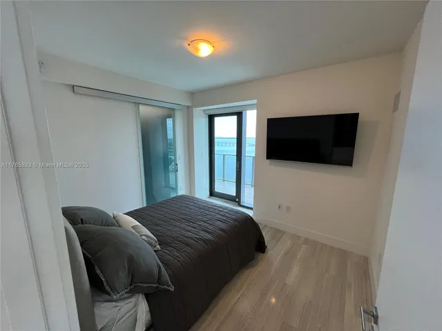 a bedroom with a bed and a flat screen tv