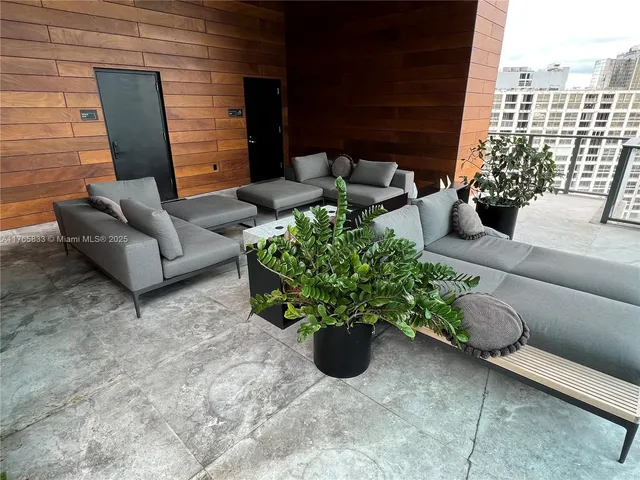 a view of a patio with couches table and chairs and potted plants