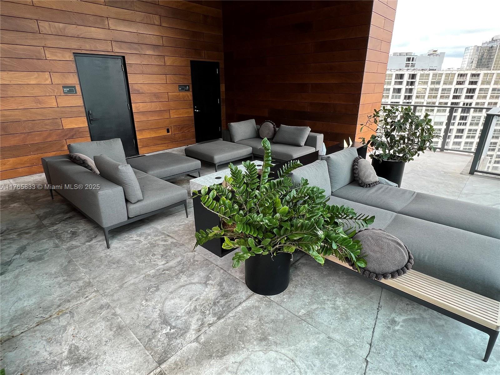 1451 Brickell Avenue, Unit 2004 Miami, FL 33131 - Photo 25 of 41 a view of a patio with couches table and chairs and potted plants