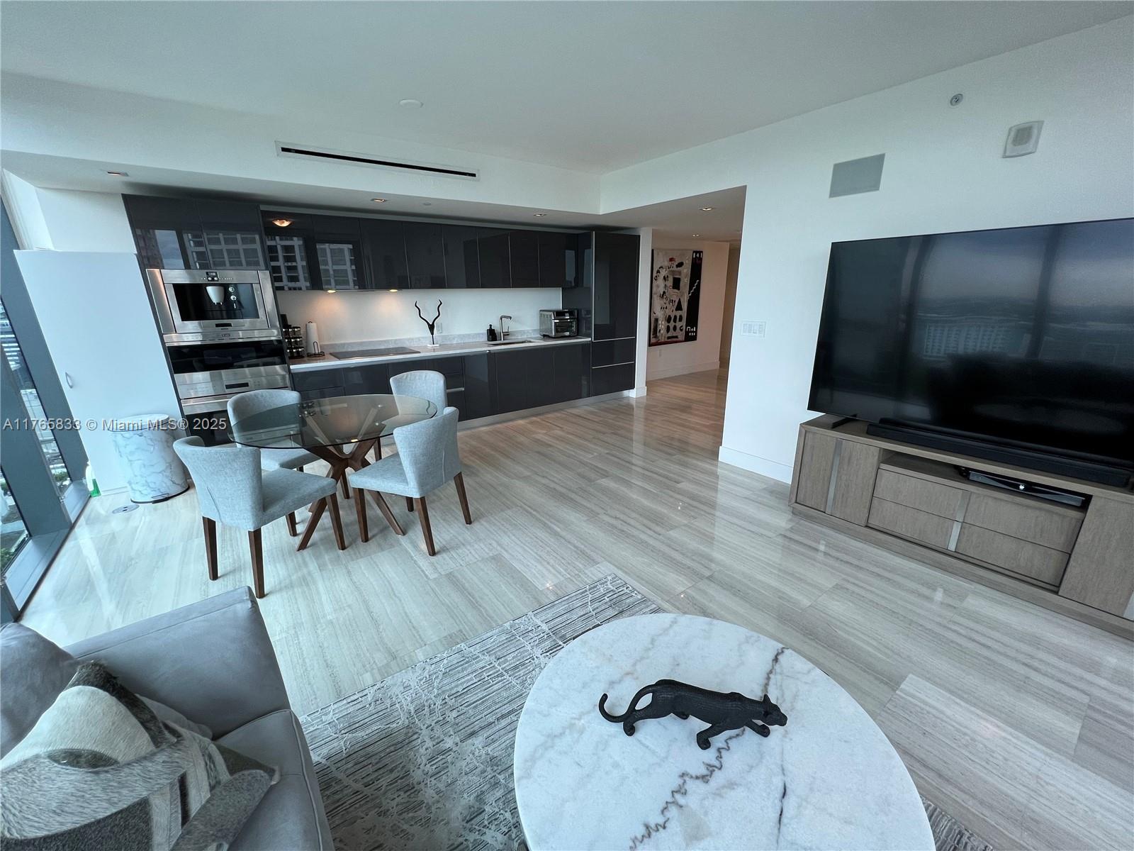 1451 Brickell Avenue, Unit 2004 Miami, FL 33131 - Photo 9 of 41 a living room with furniture and a flat screen tv