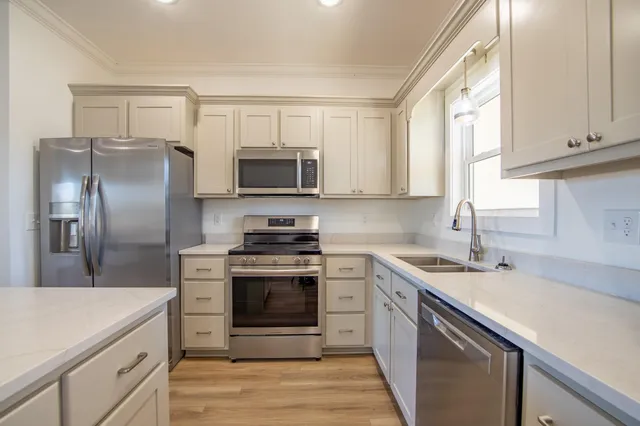 a kitchen with stainless steel appliances granite countertop a sink stove microwave and refrigerator