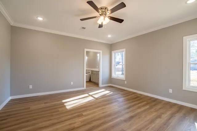 a view of an empty room with window and wooden floor