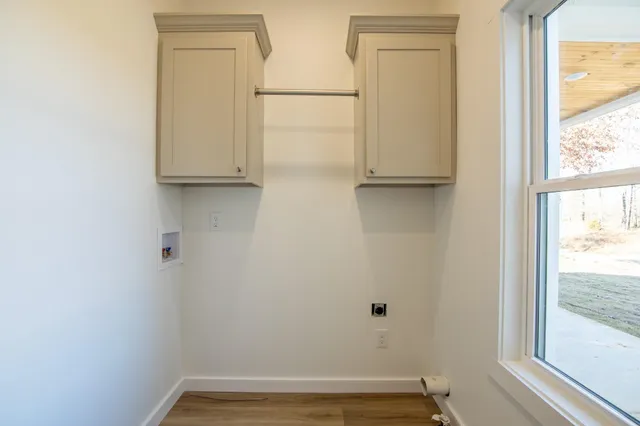 a view of a small space with wooden floor and a window