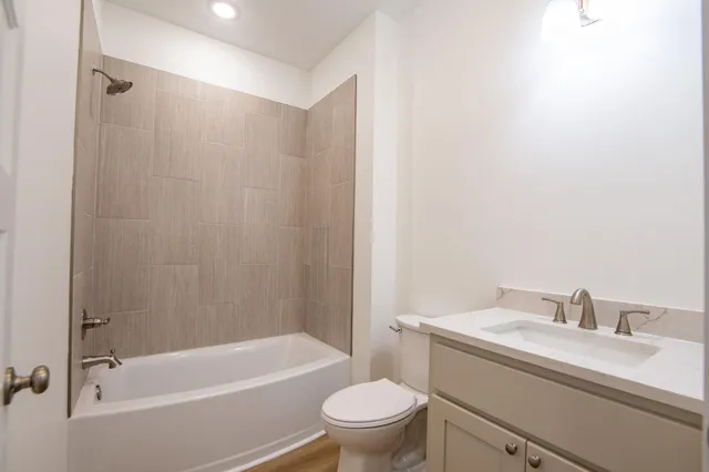 a bathroom with a granite countertop toilet a sink and a bathtub