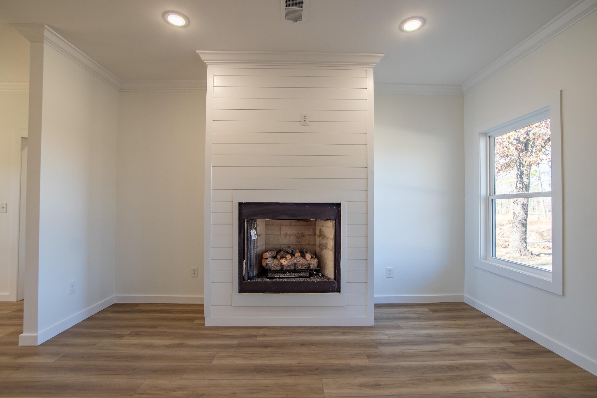 113 Braxton Lane Corinth, MS 38834 - Photo 8 of 39 a view of an empty room with wooden floor fireplace and a window