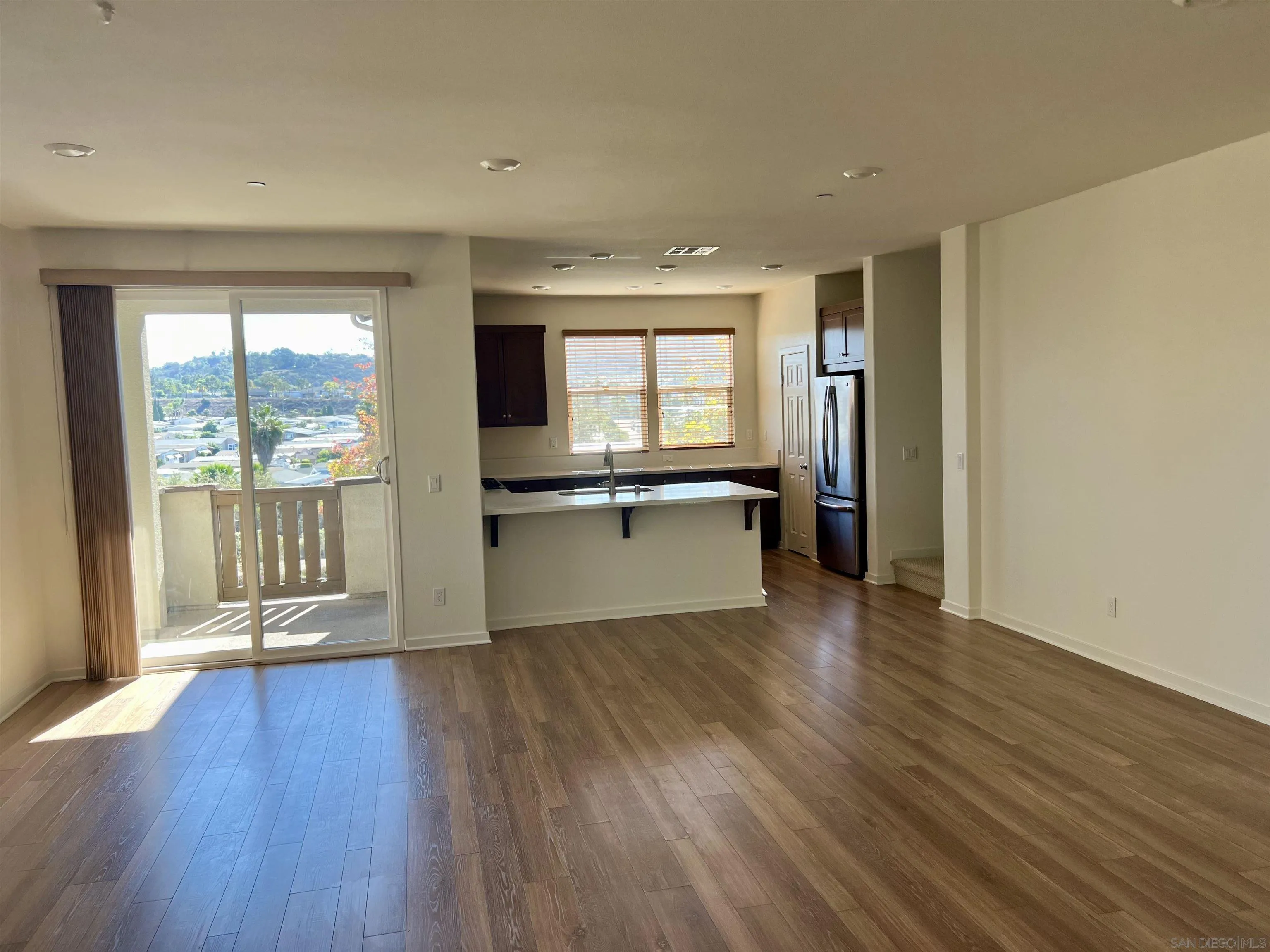415 Mission Villas Road San Marcos, CA 92069 - Photo 8 of 23 a view of a kitchen and an empty room with wooden floor and a window