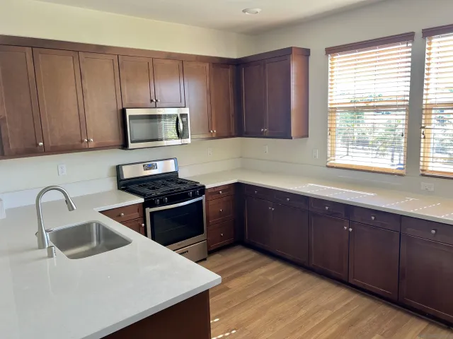 a kitchen with wooden cabinets and stainless steel appliances