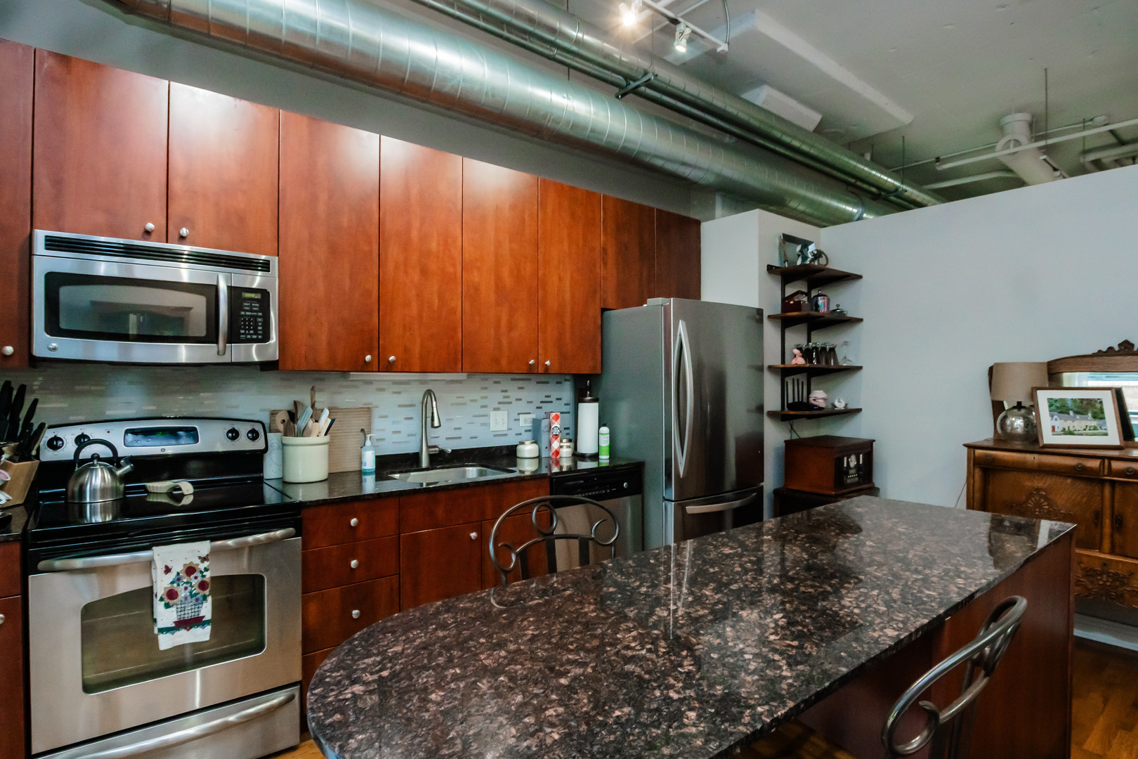 565 West Quincy Street, Unit 710 Chicago, IL 60661 - Photo 12 of 22 a kitchen with stainless steel appliances granite countertop a refrigerator a stove top oven a sink with granite countertops and cabinets