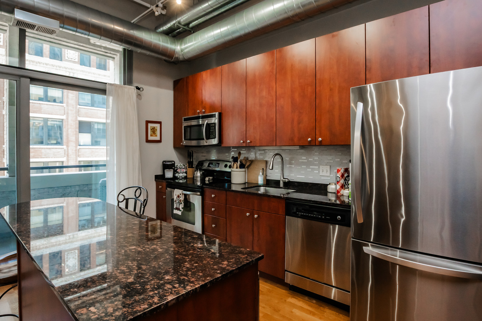 565 West Quincy Street, Unit 710 Chicago, IL 60661 - Photo 13 of 22 a kitchen with stainless steel appliances granite countertop a refrigerator stove and sink