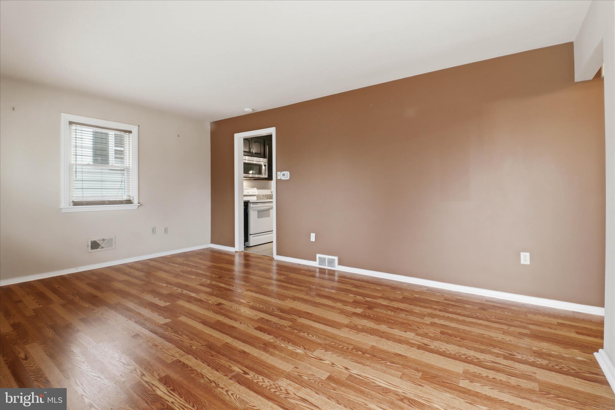 931 Rolridge Avenue Lancaster, PA 17603 - Photo 8 of 52 a view of an empty room with wooden floor and a window