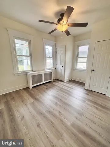 a view of a livingroom with wooden floor and a ceiling fan