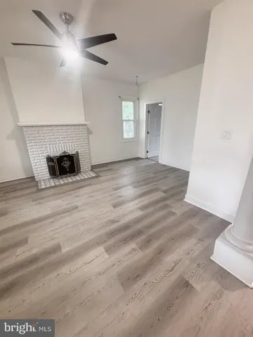 a view of an empty room with window and fireplace