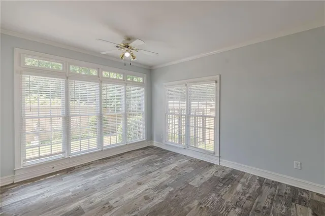 a view of an empty room with a window and wooden floor
