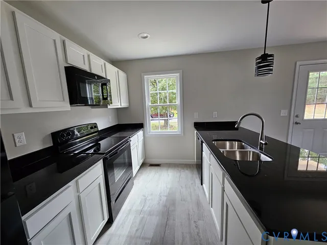 a kitchen with granite countertop stainless steel appliances a sink stove and microwave