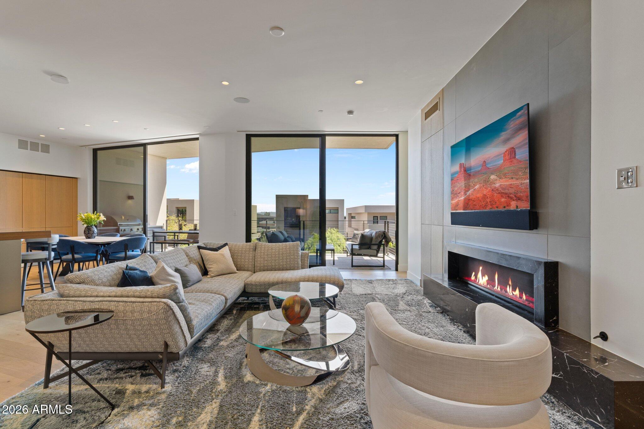 5000 North Camelback Ridge Drive, Unit 208 Scottsdale, AZ 85251 - Photo 11 of 53 a living room with furniture fireplace and a large window