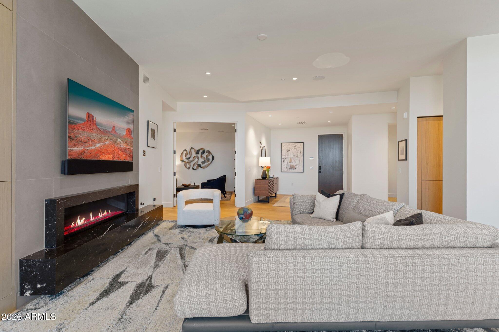 5000 North Camelback Ridge Drive, Unit 208 Scottsdale, AZ 85251 - Photo 13 of 53 a living room with furniture flat screen tv and a fireplace
