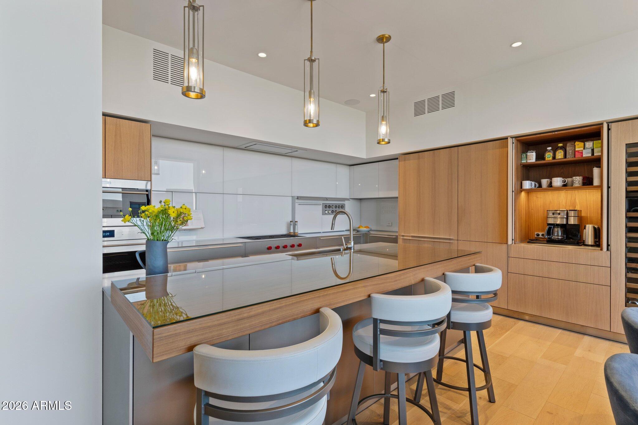 5000 North Camelback Ridge Drive, Unit 208 Scottsdale, AZ 85251 - Photo 16 of 53 a kitchen with a sink and chairs