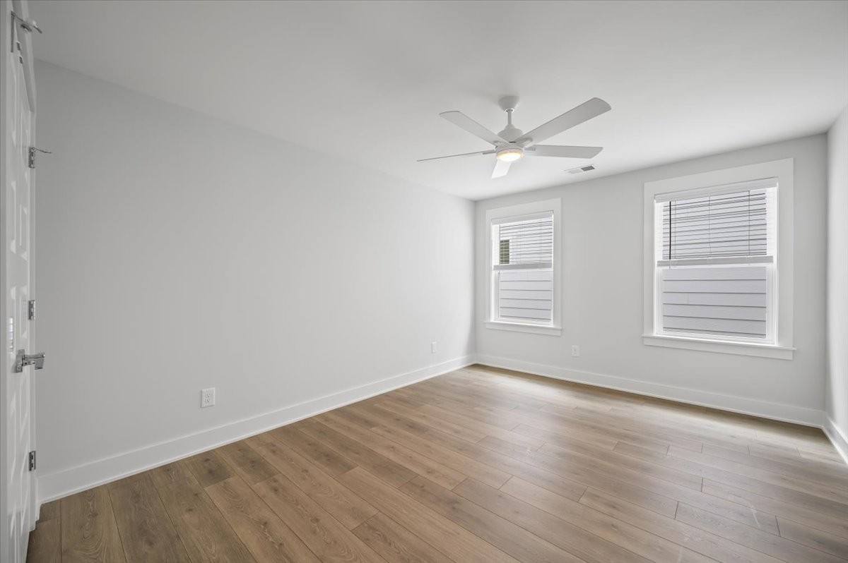 3045 B Hillside Road Nashville, TN 37207 - Photo 21 of 32 an empty room with wooden floor ceiling fan and windows