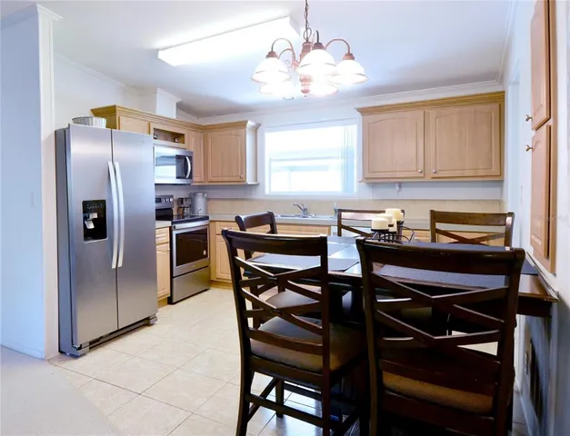 a kitchen with a table chairs refrigerator and cabinets