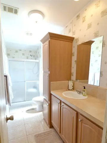 a bathroom with a sink a toilet and shower