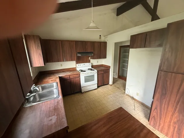 a kitchen with stainless steel appliances a stove a sink and a microwave