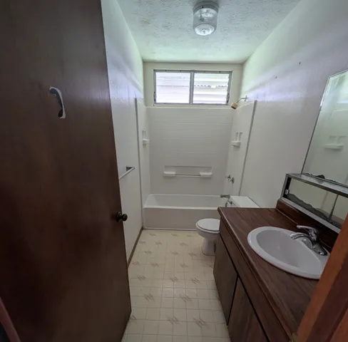 a bathroom with a sink a toilet a mirror and shower