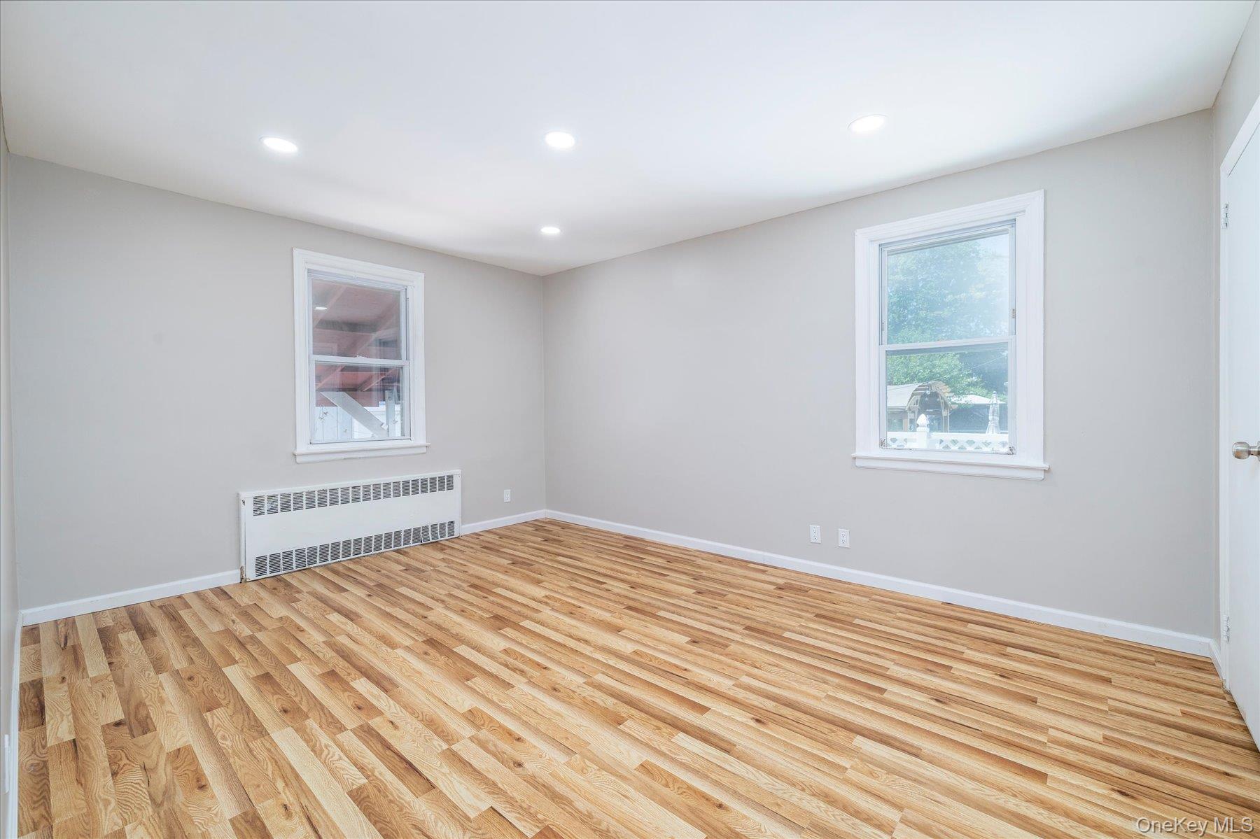 191 Raff Avenue Mineola, NY 11501 - Photo 17 of 25 a view of a bedroom with wooden floor and window