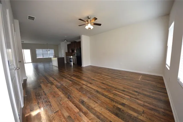 a view of a livingroom with wooden floor and a ceiling fan
