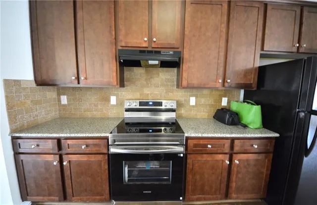 a kitchen with stainless steel appliances granite countertop a stove and a refrigerator