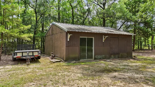 a backyard of a house with a large tree and wooden fence