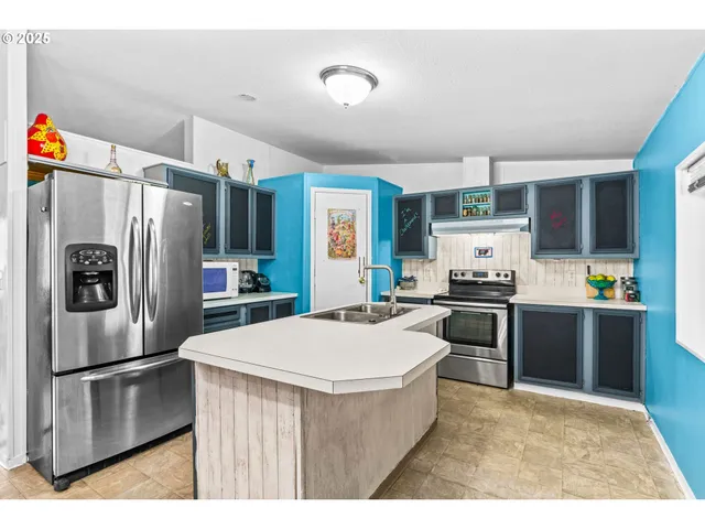 a kitchen with stainless steel appliances a refrigerator sink and stove
