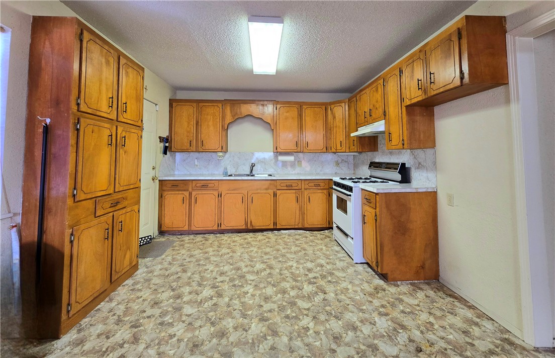 1105 East 5th Street Alice, TX 78332 - Photo 5 of 20 a kitchen with stainless steel appliances granite countertop a sink stove and refrigerator