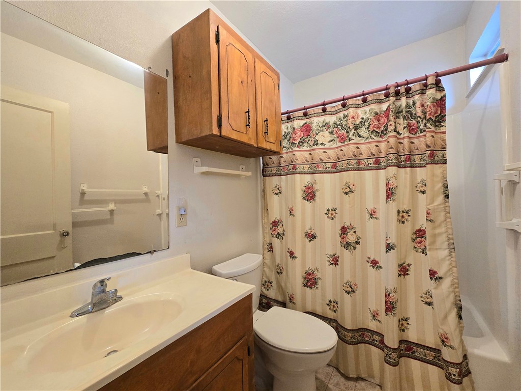 1105 East 5th Street Alice, TX 78332 - Photo 9 of 20 a bathroom with a sink toilet and shower