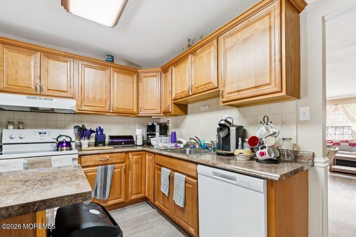 a kitchen with stainless steel appliances granite countertop a sink a stove and cabinets