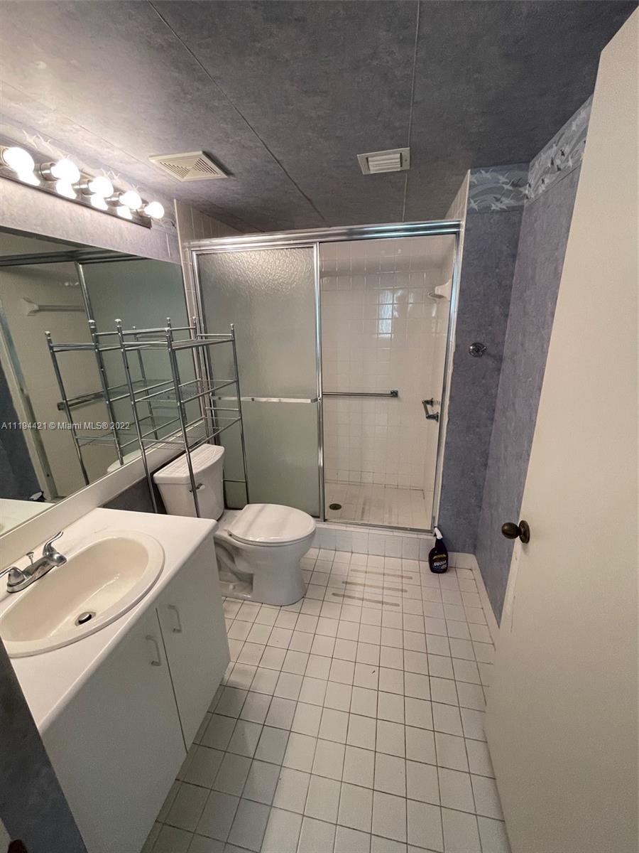 9560 Weldon Circle, Unit J102 Tamarac, FL 33321 - Photo 4 of 7 a bathroom with a toilet a sink and shower