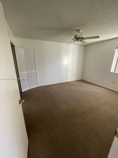 9560 Weldon Circle, Unit J102 Tamarac, FL 33321 - Photo 6 of 7 an empty room with a ceiling fan and a window