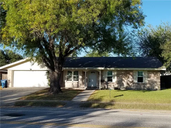 front view of house with a tree in front of it