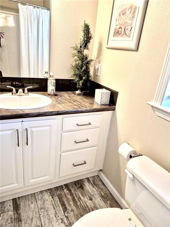 173 Redwood Lane, Unit 8 Naples, FL 34114 - Photo 14 of 19 a bathroom with a granite countertop sink and a toilet