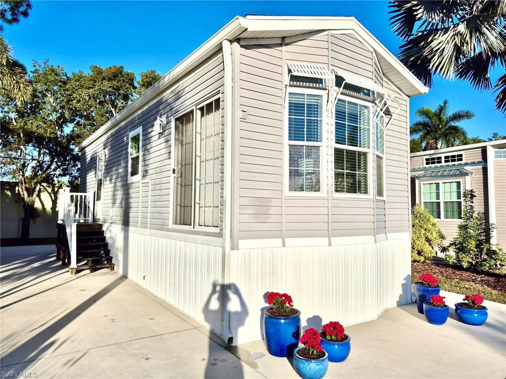 173 Redwood Lane, Unit 8 Naples, FL 34114 - Photo 2 of 19 a front view of a house with a yard