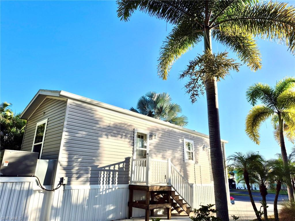173 Redwood Lane, Unit 8 Naples, FL 34114 - Photo 3 of 19 a front view of a house with a palm tree