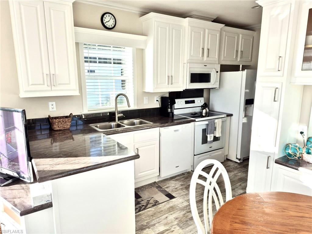 173 Redwood Lane, Unit 8 Naples, FL 34114 - Photo 9 of 19 a kitchen with stainless steel appliances granite countertop a sink a stove a refrigerator a counter space and cabinets