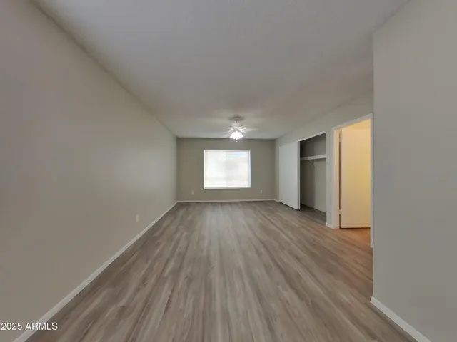 an empty room with wooden floor and window