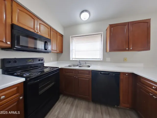 a large kitchen with wooden floor and a large window