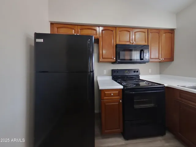 a kitchen with stainless steel appliances granite countertop wooden cabinets stove top oven and sink