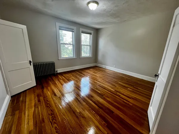 a view of an empty room and wooden floor