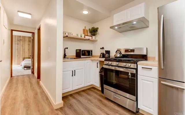 a bedroom with a bed and a large mirror with a dresser