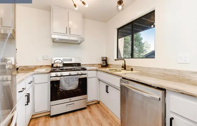 a kitchen with cabinets a sink and appliances